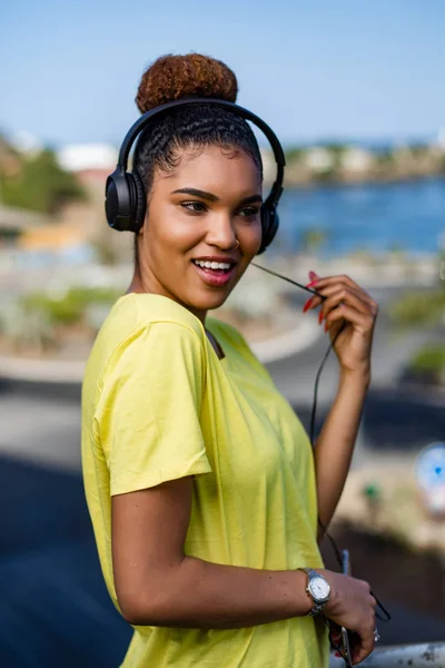 Mooie jonge zwarte Afro-Amerikaanse vrouw luisteren naar muziek wit — Stockfoto