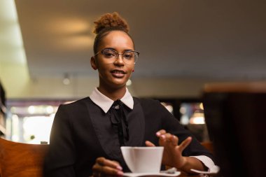 Siyah Afrikalı Amerikalı genç adam kahve içiyor.