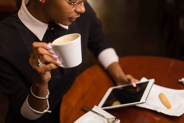 Черный африканский молодой йоман пьет кофе и пользуется футболкой — стоковое фото
