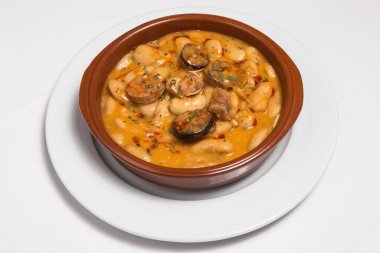 Fasulye ve pastırma güveci bir güveçte servis edilir. İspanyol mutfağı. Seçici odaklanma. Judiones de la Granja