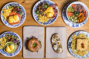 Farklı ev yapımı brunchlar, ahşap arka planda üst görünüm.