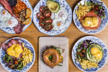 Farklı ev yapımı brunchlar, ahşap arka planda üst görünüm.