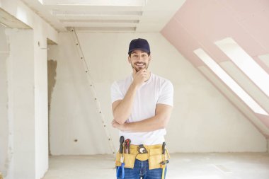 Onun çene ayakta inşaat sahasında üzerinde el ile genç düşünme el işleri ustası. 