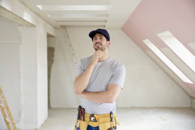 Onun çene ayakta inşaat sahasında üzerinde el ile genç düşünme el işleri ustası. 