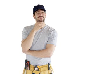 Düşünme genç tamirci çenesini izole beyaz arka plan kopya alanı ile üzerinde el ile ayakta portresi. 