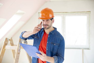 Onun el yapımı arayıp duran inşaat alanı, pano tutan genç tamirci portresi.