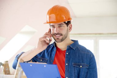 Onun el yapımı arayıp duran inşaat alanı, pano tutan genç tamirci portresi.