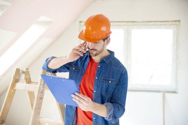 Onun el yapımı arayıp duran inşaat alanı, pano tutan genç tamirci portresi.