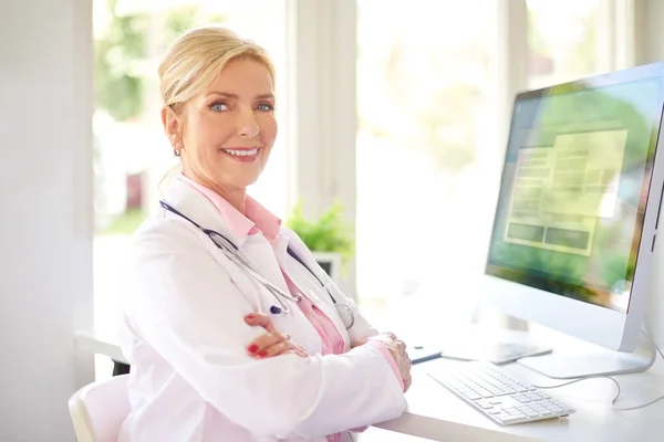 美しい笑みを浮かべて女性研究医医師のオフィスや作業の彼女のコンピューターの前に座って — ストック写真