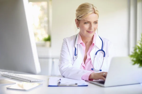 Mature Female Doctor Using Her Laptop While Sitting Doctor Office — Stock Photo, Image