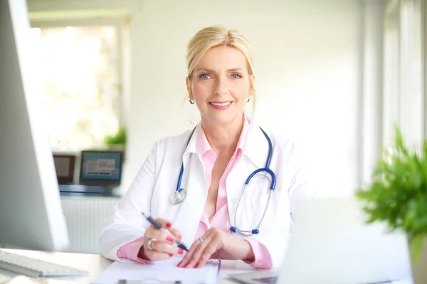 Leende Äldre Kvinnliga Läkare Använder Dator Och Laptop Och Arbetar — Stockfoto