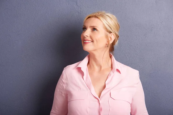 gri duvara duran gülümseyen güzel olgun kadın. 