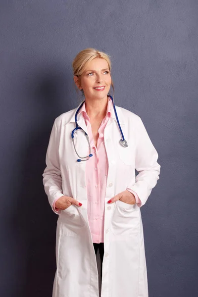 Hermosa Sonriente Médico Femenino Con Posando Fondo Gris — Foto de Stock