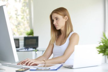 Ofis Masası bilgisayarın klavyesinden yazarak güzel genç satış asistanı iş kadını. 