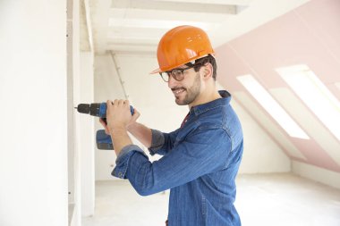 İnşaat alanında çekiç matkap sürücüyü kullanarak başarılı genç tamirci.