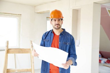 Genç erkek mühendis holding blueprint inşaatı yerinde dururken elinde portresi. 