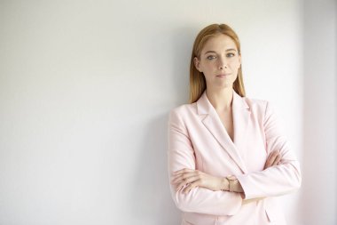 Ceket giyen ve kolları bağlı bir şekilde duvara bakarken kameraya bakan genç ve güzel bir kadının kırpılmış görüntüleri.. 