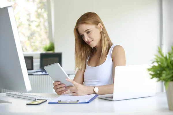 微笑着在办公室工作的年轻女人 漂亮的女商人坐在写字台前 用数码平板电脑 — 图库照片