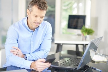 Ofiste oturan ve düşünceli kısa mesaj arıyor işadamı