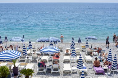Nice, Fransa -26 2018 olabilir: Görünümünü şemsiye ve şezlong mavi ve beyaz çizgili ile Promenade des Anglais'e Akdeniz'de Nice, Fransız Rivierası boyunca altında çakıl plaj