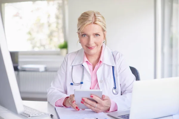 Médica Sênior Usando Touchpad Enquanto Senta Sala Médicos Frente Laptop — Fotografia de Stock
