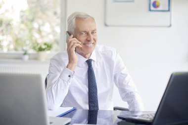 Smartphone içinde office çalışma laptop süre konuşurken çift üst düzey iş adamı