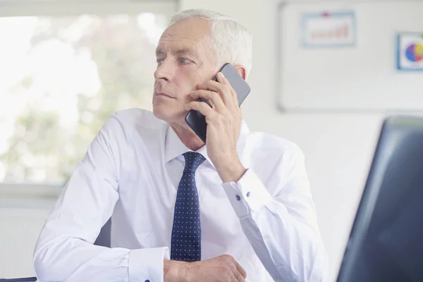 Ejecutivo Empresario Senior Hablando Teléfono Inteligente Mientras Trabaja Portátil Oficina —  Fotos de Stock