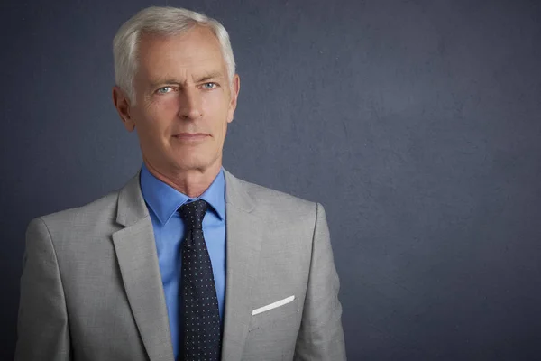 Cropped shot of senior man wearing suit posing at grey background with copy space.