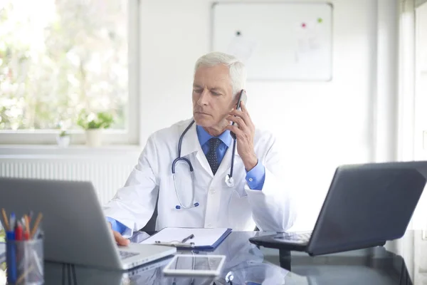 Manliga Läkare Sitter Vid Samråd Rum Och Prata Telefon — Stockfoto