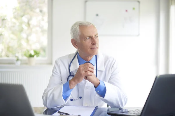 Ältere Männliche Ärztin Medizinischem Morgenmantel Sitzt Behandlungszimmer — Stockfoto