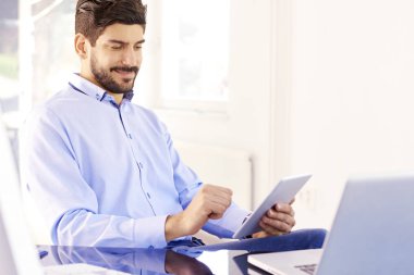 Yeni proje üzerinde çalışırken dijital tablet kullanarak satış delikanlı gülümseyen portre. 