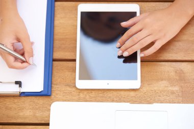 Dijital tablet dokunmaktan ve masada bir şey yazma sırasında kadın eli'nın yüksek açı çekim. 