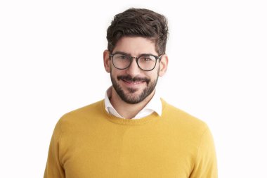 Kameraya bakarak ve gözlük ve kazak giyen süre gülümseyen rahat genç işadamı yakın çekim portre vurdu. Beyaz arka plan üzerinde izole. 