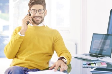 Ofiste otururken telefon görüşmesi çift genç profesyonel adam portresi. Genç işadamı cep telefonu üzerinde konuşurken.