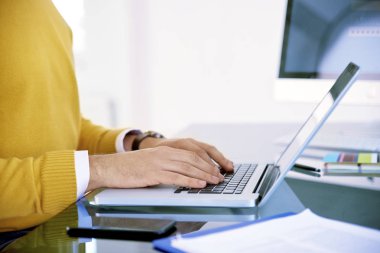 Kırpılan atış işadamı el üstünde laptop yazarken. 