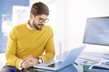 Diz üstü ofis masası, arkasında oturan ve yeni projede çalışan genç işadamı düşünme. 