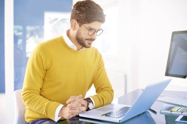 Diz üstü ofis masası, arkasında oturan ve yeni projede çalışan genç işadamı düşünme. 