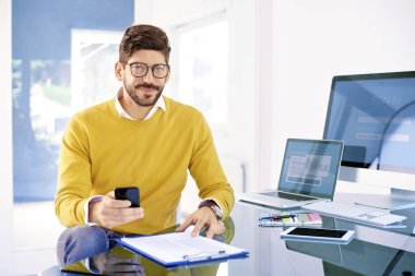 Onun cep telefonu ve metin ofis masa başında otururken haber kullanma yakışıklı genç işadamı portresi. 