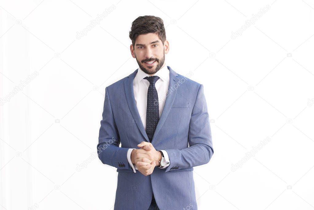 Portrait of smiling young professional businessman wearing suit and tie and smiling while standing at isolated white background. 