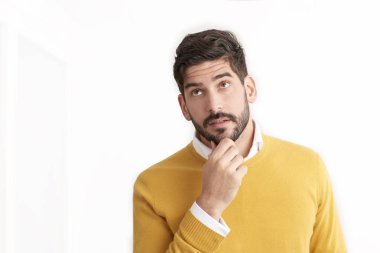 yakışıklı beyaz adam giyen sarı kazak düşünme ve beyaz arka plan poz