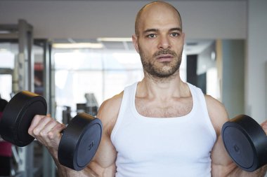 Daha kaslı vücut oluşturmak için adam yapıyor halter salonunda Close-up.