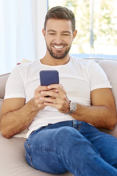 Портрет Красивого Молодого Человека Зубастой Улыбкой Сидящего Диване Текстовых Сообщениях — стоковое фото