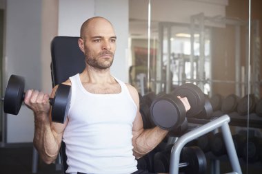 Yakın çekim daha kaslı vücut oluşturmak için adamın salonunda Barbell kullanarak ve halter egzersizleri yapıyor.