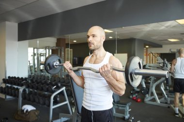 Daha kaslı vücut oluşturmak için adam yapıyor halter salonunda Close-up.