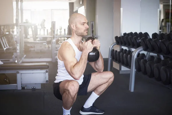 Shot of man in the gym doing dumbbell exercises to create more muscular body.