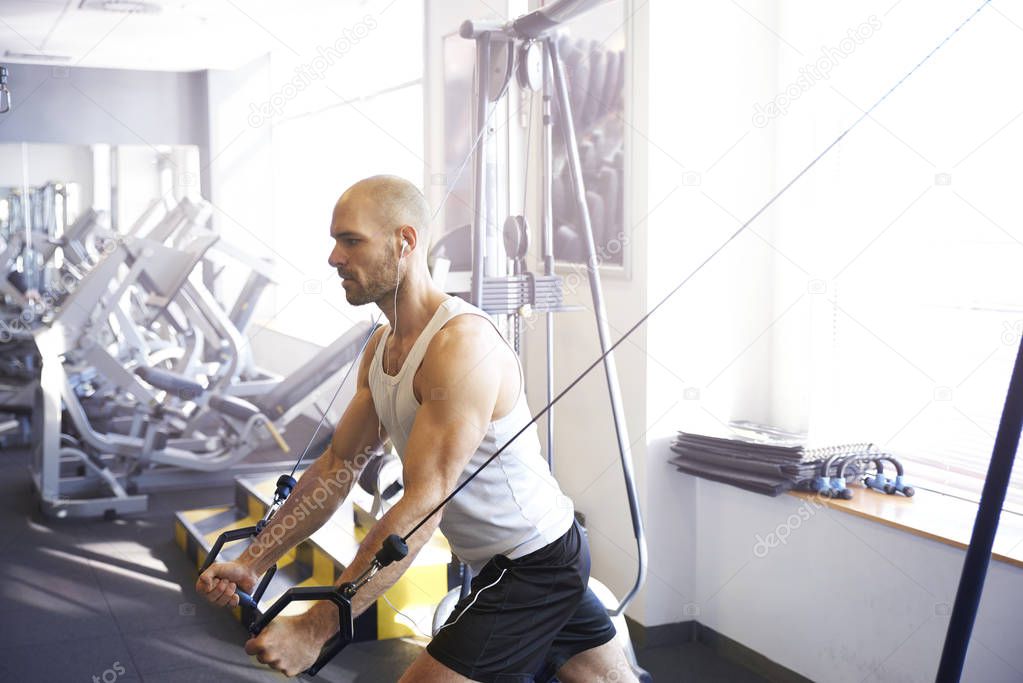 Shot of sporty man doing exercises in gym.