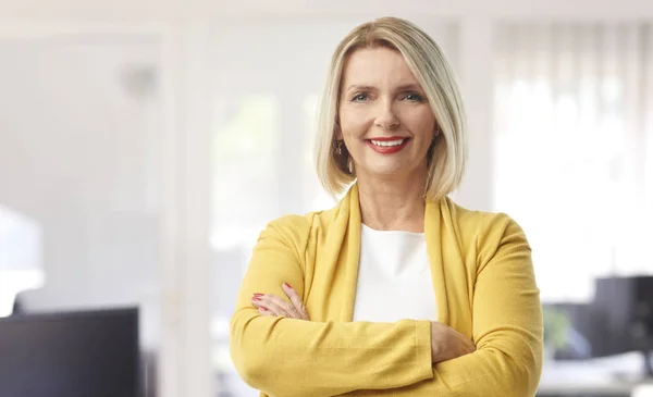 一位美丽的中年金融助理女商人穿着休闲服 在办公室站着的时候对你微笑 — 图库照片
