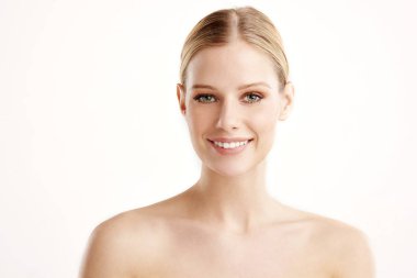 Yakın çekim stüdyo portre güzel genç kadın kameraya bakarak ve gülümseyen kusursuz cilt ile vurdu. Beyaz izole. arka plan. 