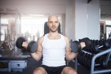 Dumbbell ise eğitim salonunda kullanan sportif adam portresi.