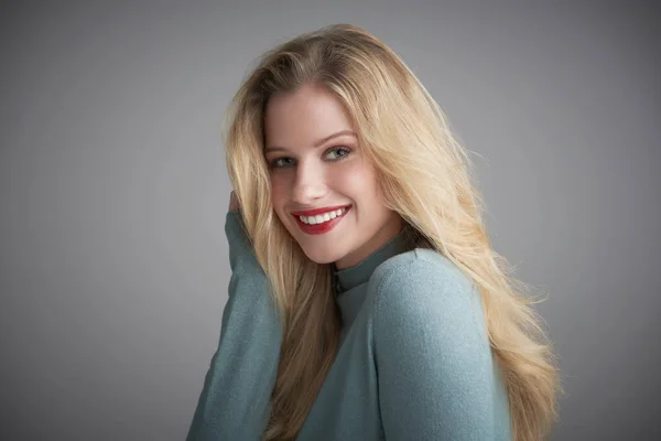 Retrato de estudio de una hermosa mujer joven mirando a la cámara y s — Foto de Stock